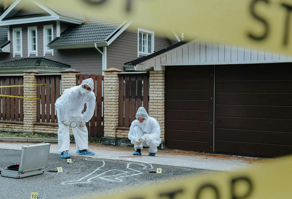 Two individuals in white protective suits checking the crime scene